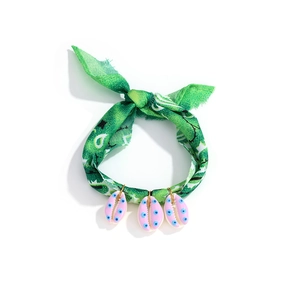 Detail of bohemian green floral fabric necklace with three pink shell charms