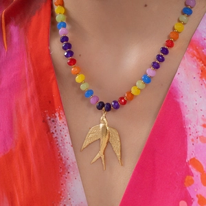 Gros plan du collier de perles arc-en-ciel avec pendentif oiseau doré sur un modèle