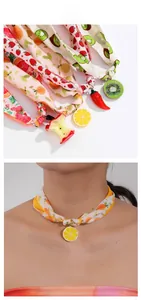 Detailed close-up of colorful fruit charm chokers with lemon and apple resin pendants