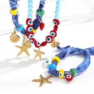 Bohemian seashell and evil eye charm necklace with blue denim fabric for beach vacation