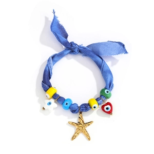 Detail of blue tie-dye fabric necklace with gold starfish and colorful evil eye beads
