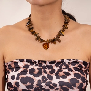 Detail of tiger eye stone necklace with a leopard print heart pendant on a model