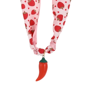 Detailed view of pink strawberry print fabric ribbon with a 3D red chili charm pendant