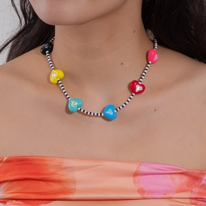 Pendentifs cœur colorés sur un collier de perles noires et blanches style dopamine