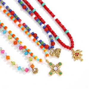 Colorful beaded necklace set featuring gold elephant, cross, and coconut tree charms