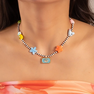 Detail of bohemian beaded necklace with colorful charms and blue evil eye pendant