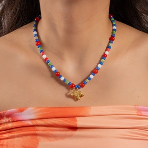 Detail of colorful beaded necklace with a golden elephant charm on a female model