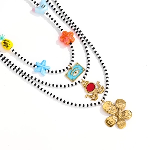 Three-layer beaded necklace with colorful enamel charms like flower and octopus