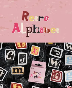 Detaillierte Makroansicht von Vintage Alphabet-Aufklebern in rosa Box auf dunklem Stein