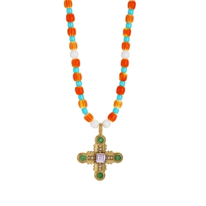 Detailed close-up of bohemian beaded necklace with vintage cross and purple gemstone