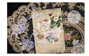 Dettaglio di adesivi rose con effetto laser su pizzo vintage e carta invecchiata