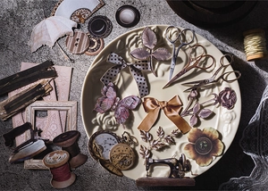 Detail of vintage scrapbooking paper cutouts with butterfly and clock patterns