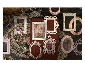 Detail of vintage Rococo resin frames with floral embossing and retro miniature artwork