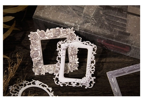 Detail of vintage Baroque style resin photo frames with rose relief and antique finish