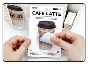 Detail of hand holding cafe latte shaped stickers with vintage aesthetic packaging