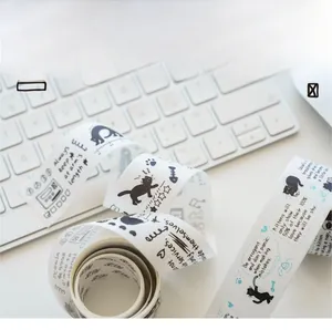 Close-up of black cat washi tape with motivational text on white keyboard background