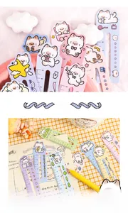 Detailed view of pastel cat bookmarks with 5cm rulers on a notebook page for journaling