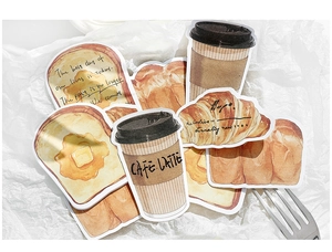 Detailed close-up of bread and coffee shaped decorative sticky notes with metallic fork decor