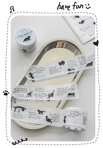 Detail of black cat washi tape featuring cute feline illustrations and quotes on metal tray