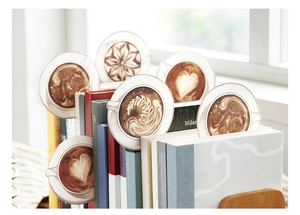 Detail showing latte art coffee cup bookmarks styled inside books for stationery decor