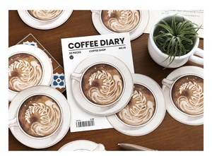 Close-up of 30pcs coffee latte art stickers for journaling on dark wood surface