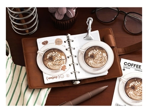 Close-up of 30pcs coffee latte art sticky notes in a vintage leather journal setup