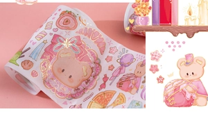 Vista dettagliata del nastro adesivo washi con orso cartone animato e dolci dorati