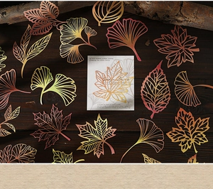 Detalle de recortes de papel en forma de hojas coloridas sobre fondo de madera oscura