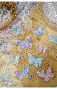 Détails d'autocollants papillons en PET irisé avec finition laser sur fond papier vintage