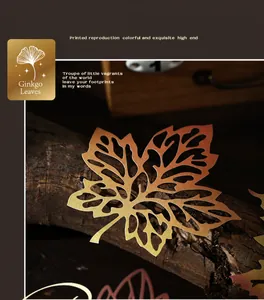 Exquisitas hojas de ginkgo talladas en papel dorado con texturas sobre madera