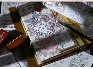 Détail du kit de scrapbooking vintage avec tampons en bois, stickers horloge et fleurs