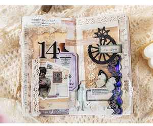 Detail van vintage scrapbook materiaalkit met kant, vlinderstickers en oude krantenstijl