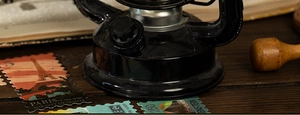 Detalle macro de una linterna retro de metal negro con perilla y sellos decorativos