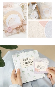 Detail of vintage scrapbook material kit with embossed butterfly and Cupid Garden notebook