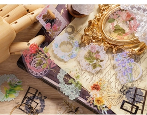 Detailed close-up of vintage PET floral stickers on an antique wood and book background