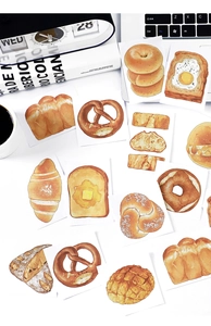 Close-up of watercolor bakery stickers featuring pretzels, bagels and croissants for journaling
