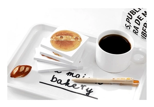 Flat lay of bread themed memo pads with realistic bakery illustrations on a white tray