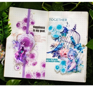 Detail showing floral fairy stickers with blue flowers and moss on a bullet journal