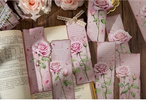 Macro shot of vintage rose-themed bookmarks with floral illustrations and lace details