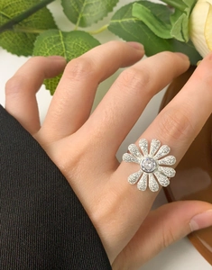 Detail of S925 silver daisy ring on finger showing micro-pave cubic zirconia setting