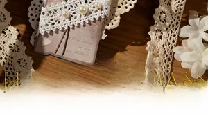 Detail of vintage flower bookmark with delicate lace edges and faux pearl accents