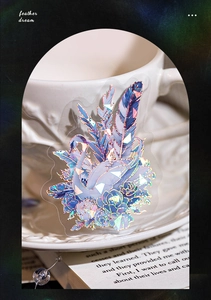 Detailed view of laser gold PET feather and swan sticker with iridescent finish for scrapbooks