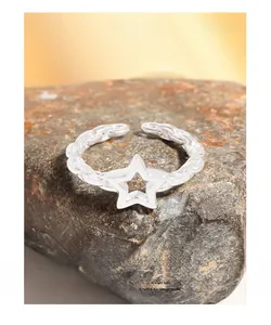 Detailed view of S925 sterling silver star ring with chain band on natural rock texture