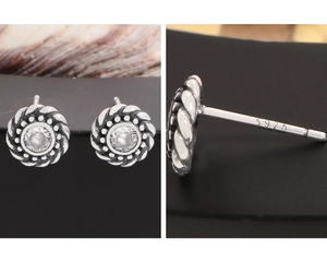 Macro detail of S925 sterling silver twist stud earrings featuring a clear zircon stone