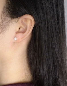 Gros plan d'un éclatant clou d'oreille en zircon avec sertissage à griffes classique
