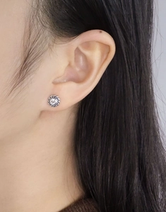 Close-up of vintage twist stud earring with zircon on ear showing realistic texture