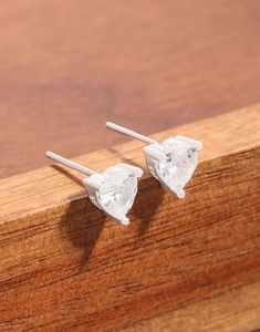 Vue macro des boucles d'oreilles cœur en argent S925 avec zircons transparents
