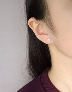 Gros plan de boucles d'oreilles cœur en argent avec zircone portées par un mannequin