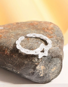 Close-up of S925 sterling silver chain ring with hollow star on dark natural rock
