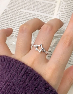 Detail view of a S925 sterling silver star ring with chain textured band on a model
